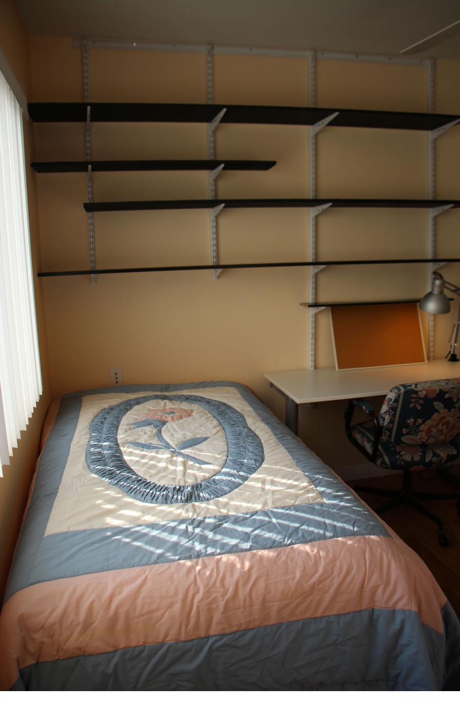 Bedroom with adjustable shelving ready for move-in at CSULA student housing