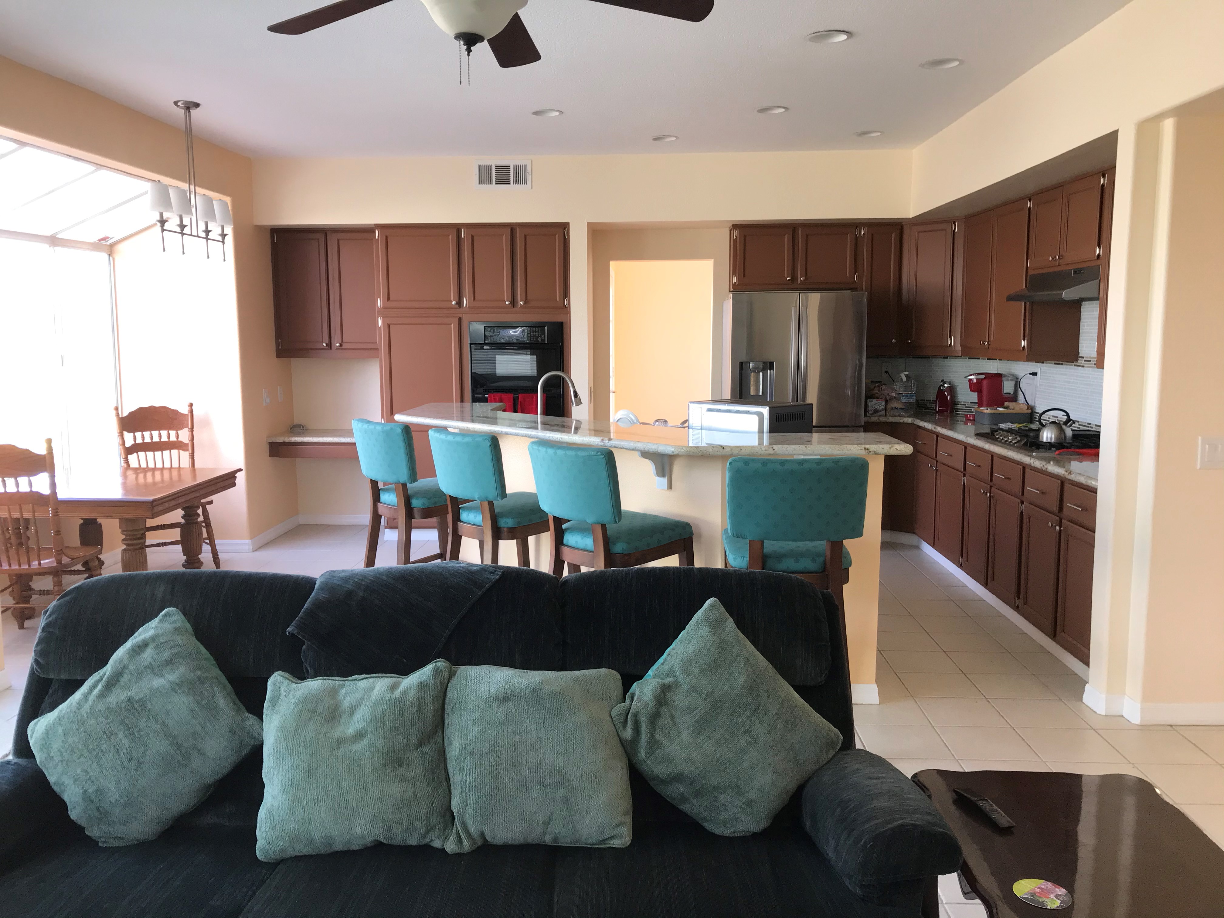 Kitchen and dining area with granite island, gas range, and stainless French-door refrigerator