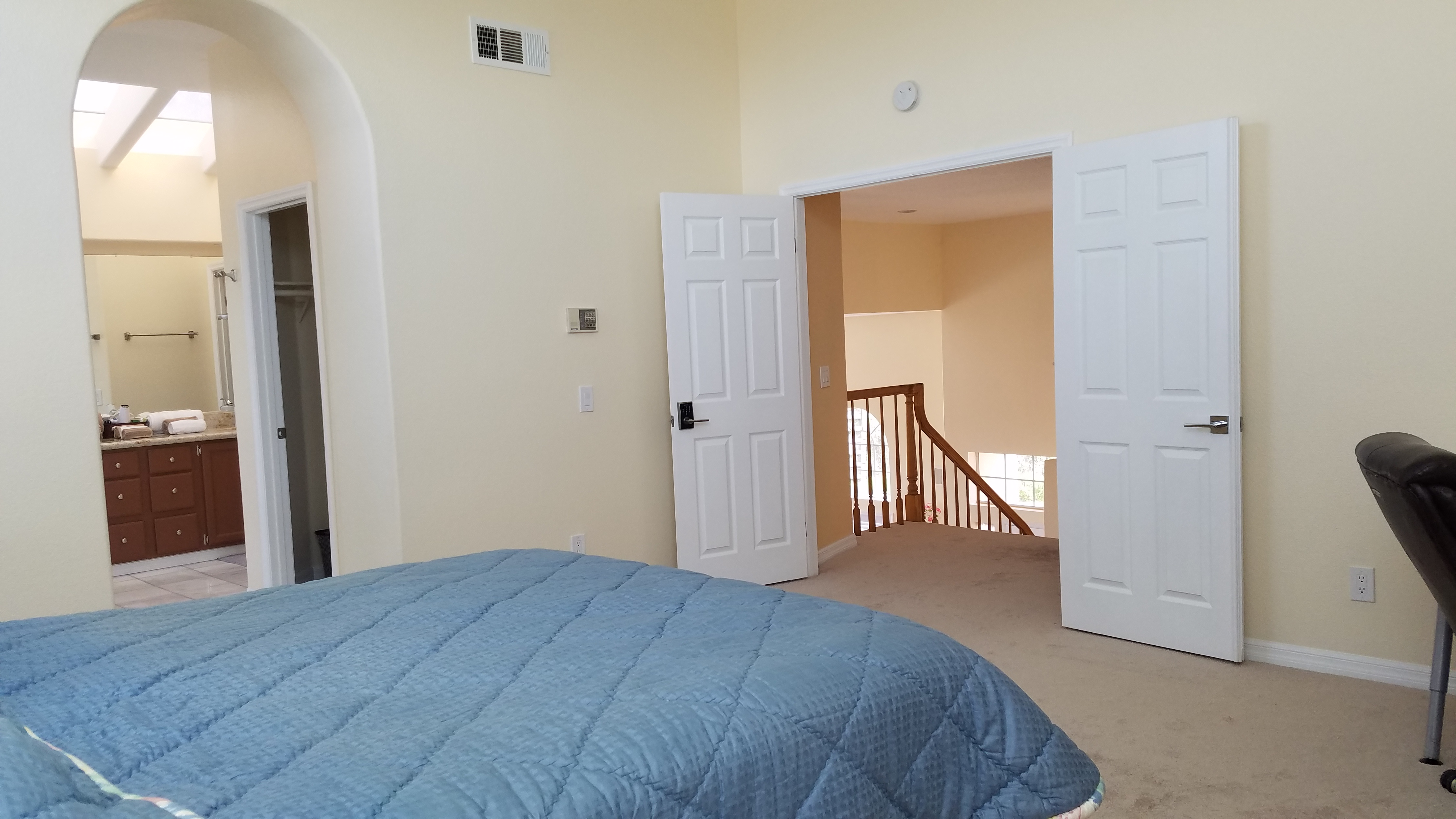 Master bedroom double-door entry with view into private en-suite bathroom