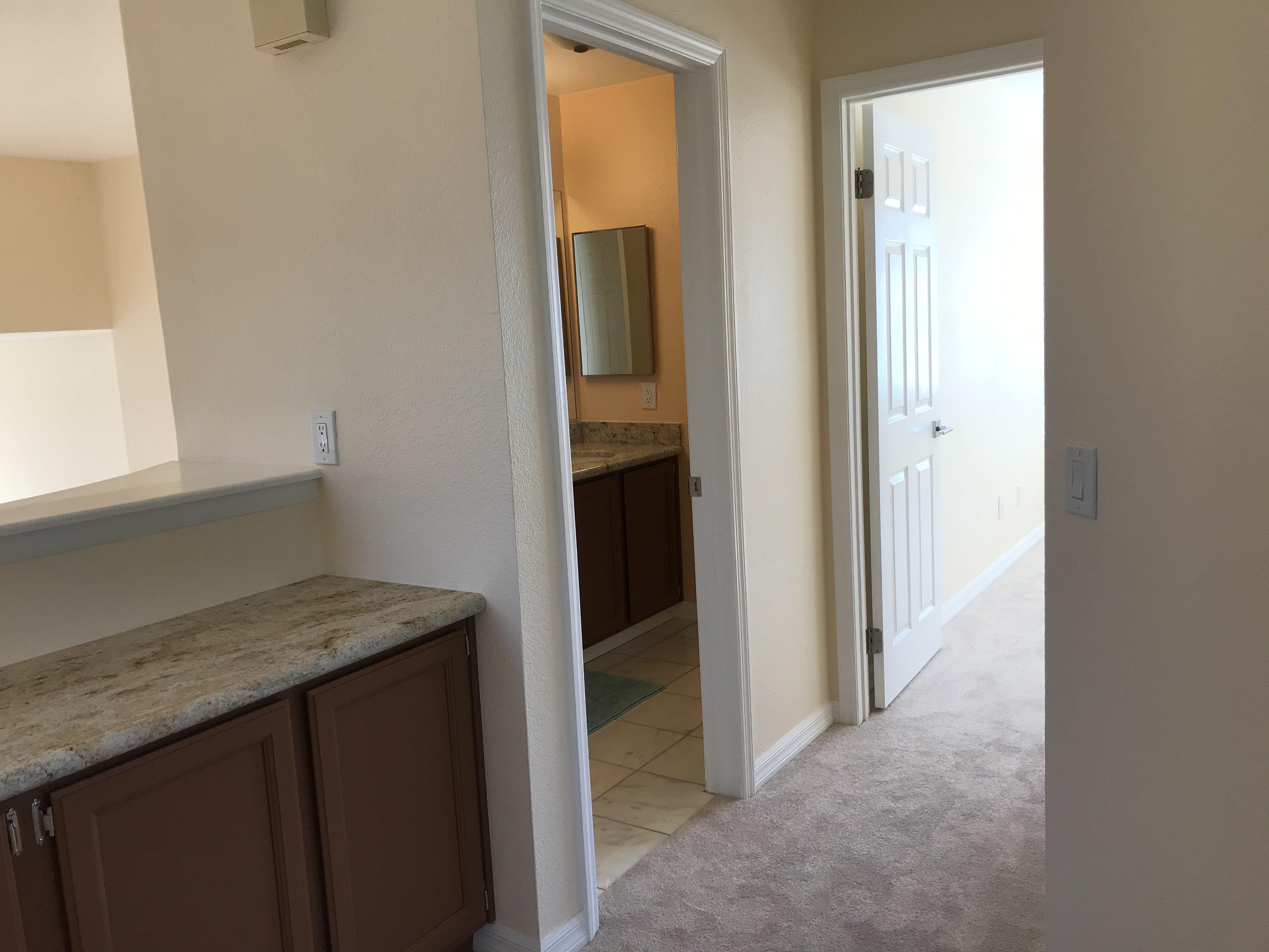 Upstairs bathroom entrance and vanity area with granite countertop and dark wood cabinetry