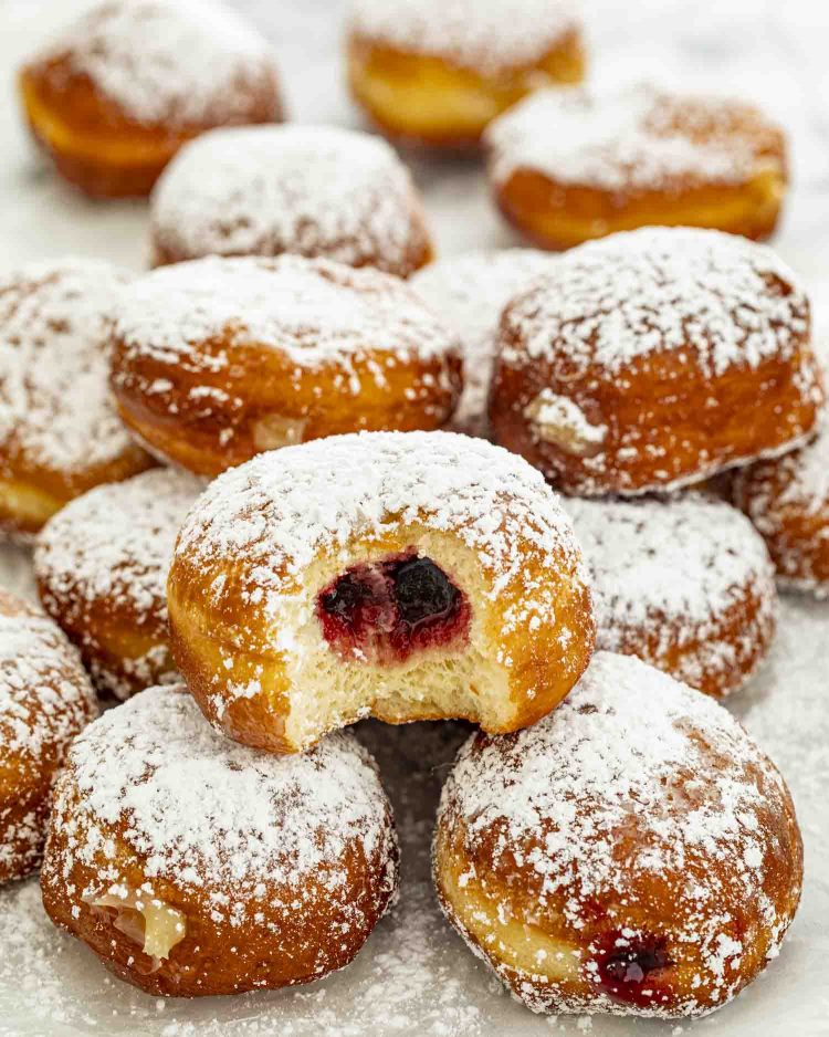 Polish pączki doughnuts dusted with powdered sugar, filled with fruit